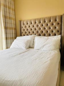 een slaapkamer met een groot bed met een getuft hoofdeinde bij Loreho boutique in Mahikeng