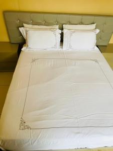 een groot bed met witte lakens en kussens bij Loreho boutique in Mahikeng