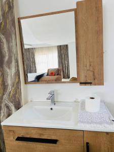 een badkamer met een wastafel en een spiegel bij Loreho boutique in Mahikeng