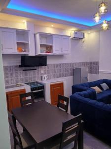 una cucina e un soggiorno con un tavolo e un divano di Villa MBOLO a Pointe-Noire