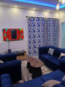 un soggiorno con un divano blu e un tavolo di Villa MBOLO a Pointe-Noire