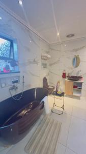 een badkamer met een bad in een kamer bij Princess & Alfreds Palace in Gqeberha