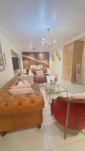 een grote kamer met een bed en een bank bij Princess & Alfreds Palace in Gqeberha +28 foto's