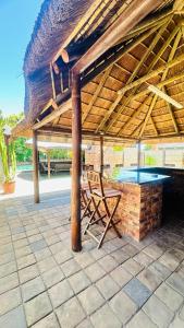 een bankje onder een paviljoen met een tafeltennistafel bij Princess & Alfreds Palace in Gqeberha