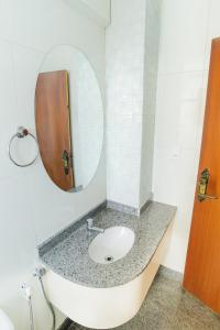 a bathroom with a sink and a mirror at Hotel & Restaurante Paraíso Ponte Nova - Ponte Nova - MG in Ponte Nova +41 photos