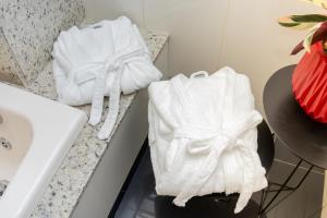 two towels sitting on a counter in a bathroom at Hotel & Restaurante Paraíso Ponte Nova - Ponte Nova - MG in Ponte Nova