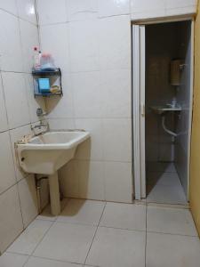 een witte badkamer met een wastafel en een douche bij Aluguel de Casa de Férias in Santa Branca