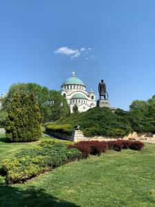 a building with a statue in the middle of a park at Stella Di Notte City Center Studios in Belgrade