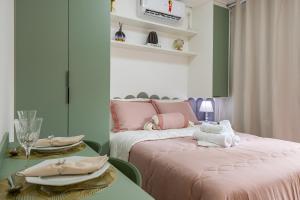 a room with two beds and a table with plates at Apê novo, moderno, a 50 metros metrô República in São Paulo +24 photos