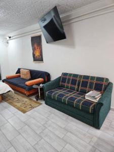 un soggiorno con un divano e una TV di BOMBA Apartman a Târgu Secuiesc