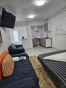a room with two beds and a couch and a kitchen at BOMBA Apartman in Târgu Secuiesc +4 photos