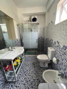 a blue and white bathroom with a toilet and a sink at Galle City Guest in Galle