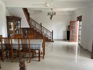 a dining room with a table and chairs and a staircase at Galle City Guest in Galle