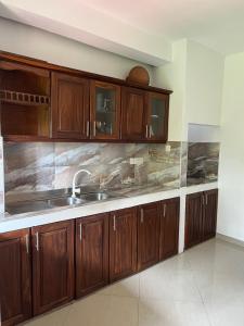a kitchen with wooden cabinets and a sink at Galle City Guest in Galle