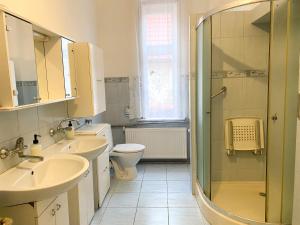 a bathroom with two sinks a toilet and a shower at Uzdrowiskowe Retro by LibertaRent in Szczawno-Zdrój
