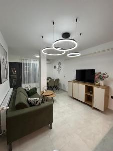 un salon avec un canapé vert et une télévision dans l'établissement Apartman MARIA 3, à Kutina