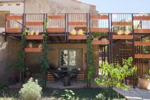 ein Balkon eines Hauses mit einem Tisch und Stühlen in der Unterkunft Cal Teixidor in Mediona