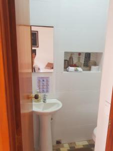 a bathroom with a sink and a toilet and a mirror at HOTEL EL SOL DEL GALERAs in Pasto