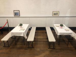two tables and benches with plants on them in a room at 215 Queen's FOR EVENTS ONLY NO OVERNIGHT STAY in Melbourne