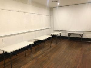 une salle de classe avec quatre tables et un grand tableau blanc dans l'établissement Queen's Duplex, à Melbourne