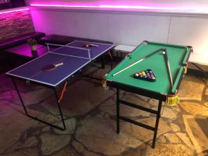 - deux tables de ping-pong dans une pièce avec un billard dans l'établissement Queen's Duplex, à Melbourne