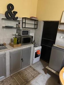 a kitchen with a stove and a microwave at Ô bien être in Saint-Louis +15 photos