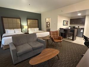 a hotel room with a bed and a couch at Best Western Plus Chihuahua Juventud in Chihuahua