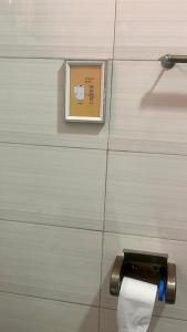 een toiletpapierdispenser op een muur met een foto bij Pure Haven in Mbale