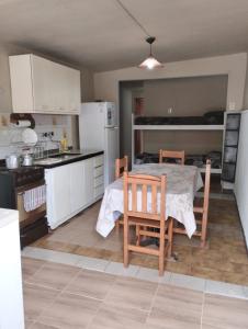 a kitchen with a table and chairs and a kitchen with white cabinets at Depto TOMY in Mar de Ajó
