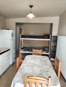 a kitchen with a table and two chairs and a refrigerator at Depto TOMY in Mar de Ajó +3 photos