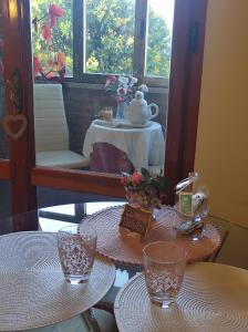 two tables with glasses and a mirror in a room at Affittacamere Casa Mac & Rose in San Quirico dʼOrcia