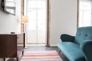 a living room with a blue couch and a table at Porto República Suites in Porto