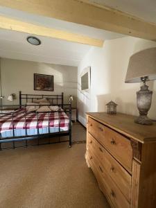 ein Schlafzimmer mit einem Bett und eine Kommode mit einer Lampe in der Unterkunft Holiday home Elena in Slenaken