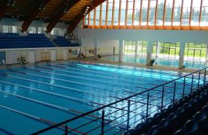 a large swimming pool with blue seats in a building at Betty Panzio in Miercurea-Ciuc
