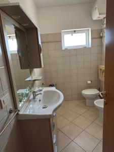 een badkamer met een wastafel en een toilet bij LYLLY'S Apartment in Santa Maria