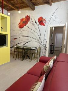 L'Abbraccio في تيفولي: غرفة معيشة مع أريكة حمراء وطاولة