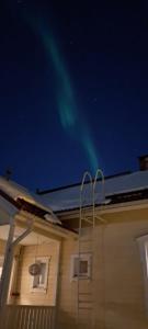 an image of the northern lights in the sky above a house at Spacious detached house for a larger group in Rovaniemi