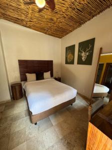 een slaapkamer met een bed en een plafondventilator bij Hotel Kupuri in Sayulita