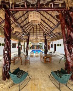een paviljoen met stoelen en tafels en een zwembad bij Hotel Kupuri in Sayulita
