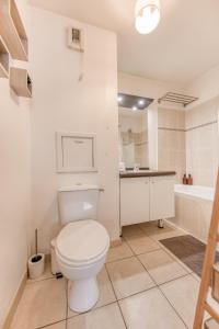 een badkamer met toilet, wastafel en bad bij Appartement 39m2 - Free Parking - Rer C - Métro 13-14 - Ascenseur - Easy Check in - in Asnières-sur-Seine