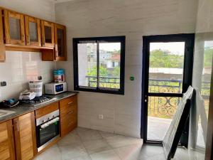 a kitchen with a door open to a balcony at Résidence Prestige KGV Appt 303 in Douala