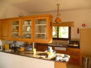 a kitchen with wooden cabinets and a counter top at Villa Manzanillo in Coral Bay