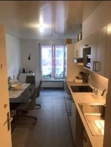 eine Küche mit einer Theke, einem Tisch und einem Fenster in der Unterkunft Quarto lux Centro Geneve 5 estrela in Arni Alp