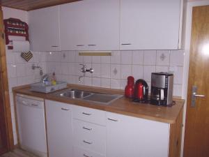a kitchen with white cabinets and a sink at Holiday Home Sequoia by Interhome in Hahnenklee-Bockswiese +22 photos