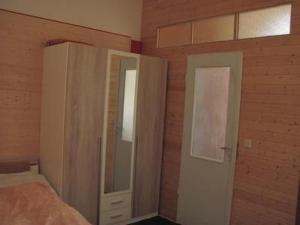 a bedroom with a bed and a cabinet with a mirror at Apartment Kunst Asyl by Interhome in Quedlinburg +8 photos