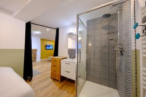 ein Badezimmer mit Glasdusche und ein Schlafzimmer in der Unterkunft Elbeuf - Appartement moderne pour 4 in Elbeuf