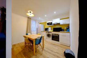 eine Küche mit einem Holztisch und einem Esszimmer in der Unterkunft Elbeuf - Appartement moderne pour 4 in Elbeuf