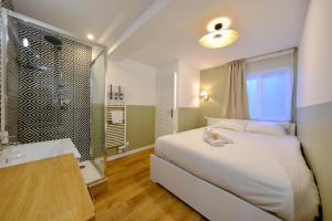 ein Schlafzimmer mit einem großen Bett und einer Badewanne in der Unterkunft Elbeuf - Appartement moderne pour 4 in Elbeuf