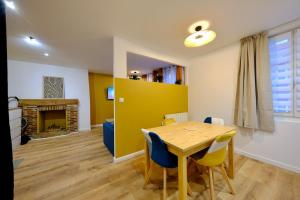 ein Esszimmer mit Tisch und Kamin in der Unterkunft Elbeuf - Appartement moderne pour 4 in Elbeuf + 15 Fotos