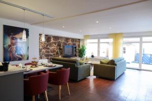 a living room with a couch and chairs and a tv at Ferienwohnung Zum Alten Cafè in Neustadt